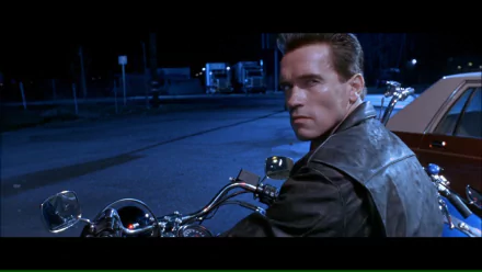 Arnold Schwarzenegger as the Terminator in a scene from Terminator 2: Judgment Day, showcasing his iconic look while riding a motorcycle at night.