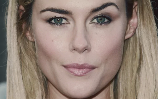 Close-up HD desktop wallpaper of celebrity Rachael Taylor with blonde hair and green eyes, showcasing her natural makeup and confident expression.