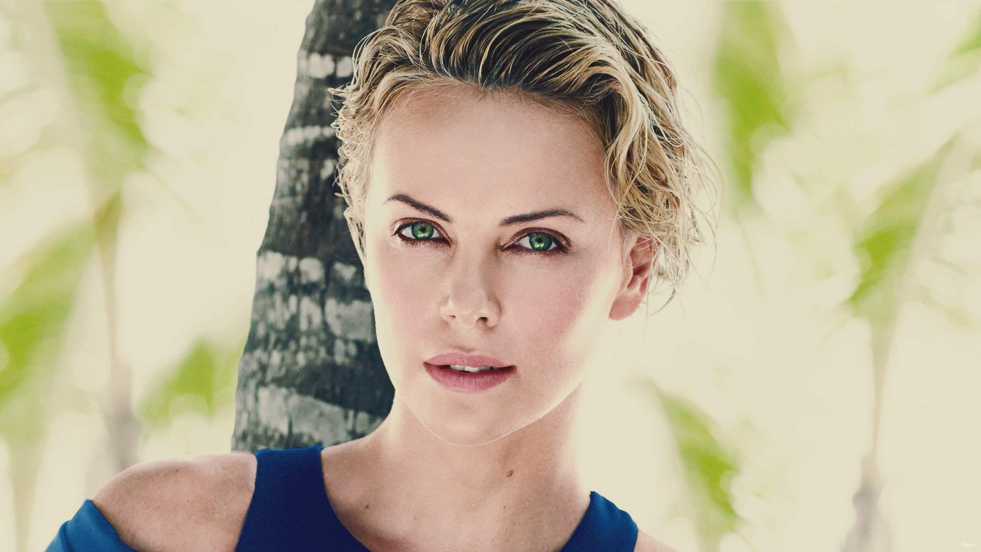 HD wallpaper featuring celebrity Charlize Theron with captivating green eyes, set against a backdrop of lush greenery. A striking and vibrant desktop background choice.