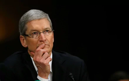 HD desktop wallpaper featuring a man in a black suit, resting his chin on his hand, looking pensive against a blurred background.