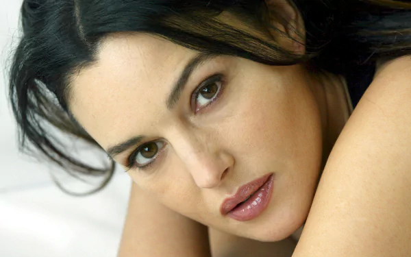 Close-up of Italian actress and celebrity Monica Bellucci, featuring a high-definition desktop wallpaper with her looking intently at the camera.