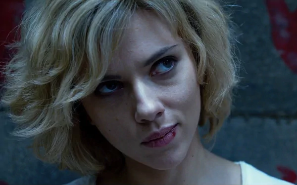 Scarlett Johansson in a scene from the movie Lucy, featuring her iconic blonde hairstyle. This HD wallpaper captures her intense expression and the film's intriguing atmosphere.