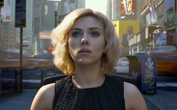 A striking HD wallpaper featuring Scarlett Johansson as Lucy, standing confidently in a bustling urban scene, capturing the film's dynamic energy.