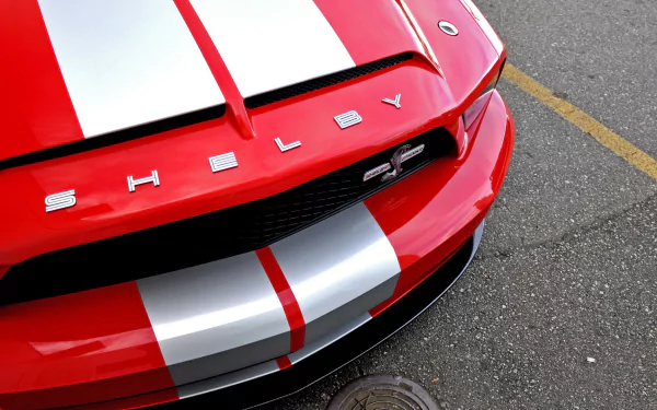 Close-up HD desktop wallpaper of a red Ford Mustang Shelby Cobra GT 500 with white racing stripes.