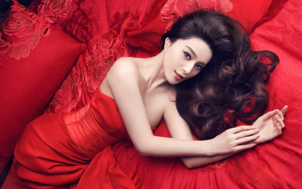 A stunning HD wallpaper featuring Chinese actress Fan Bingbing, elegantly posed in a vibrant red dress against a backdrop of rich red textures, exuding glamour and sophistication.