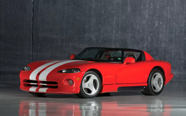 Red Dodge Viper RT/10 Roadster with white racing stripes on a reflective floor against a concrete wall — HD PC desktop wallpaper of the vehicle.