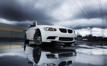 White BMW 3 Series vehicle parked on wet pavement under stormy sky, reflected in puddles — 2K Quad HD PC desktop wallpaper background.