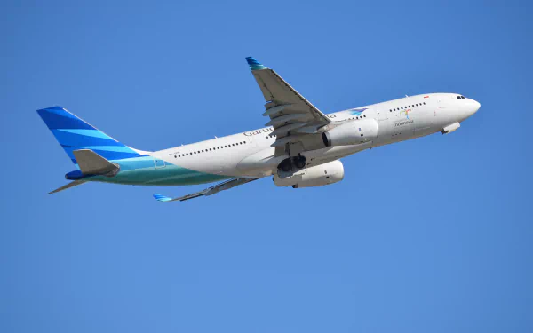 An Airbus A330 aircraft flying against a clear blue sky, showcasing its sleek design and vibrant livery, serves as a captivating HD desktop wallpaper background.