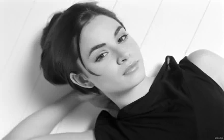 Black-and-white HD desktop wallpaper featuring celebrity Mía Maestro reclining with a calm, confident expression.