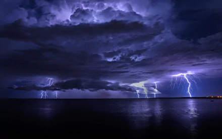 HD PC desktop wallpaper showcasing dramatic lightning bolts illuminating a dark, stormy sky over calm water, captured in stunning photography detail.