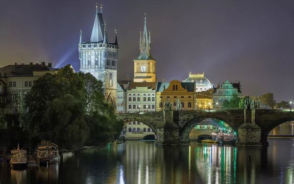 HD PC desktop wallpaper and background: nighttime Prague riverside with illuminated man-made bridges and Gothic towers reflected on the Vltava.