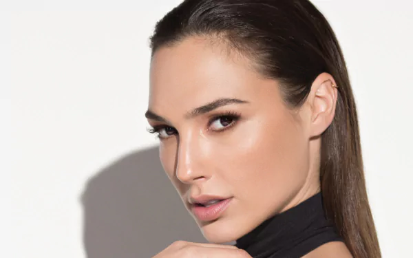 A striking HD wallpaper featuring Gal Gadot, the renowned Israeli actress, exuding elegance and confidence with a captivating gaze and sleek hairstyle against a minimalist background.