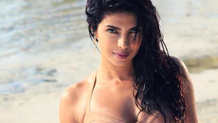 A stunning HD wallpaper featuring Indian celebrity Priyanka Chopra, capturing her in a beach setting with wet, wavy hair and a captivating expression.