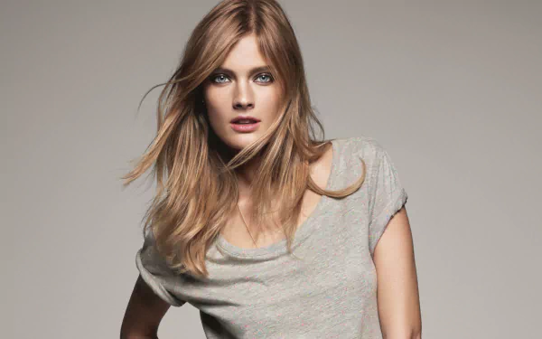 HD PC desktop wallpaper: studio portrait of a female fashion model in a casual grey tee, blonde hair and direct gaze.