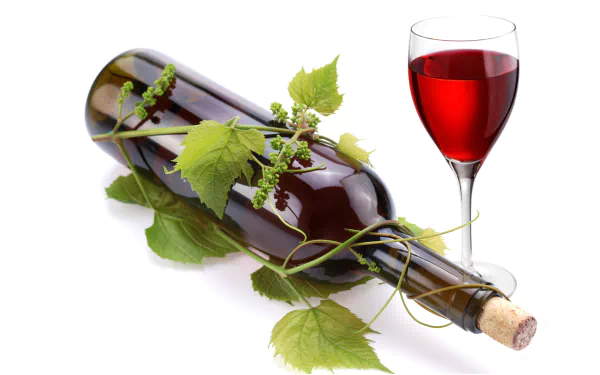 8K Ultra HD wallpaper featuring a bottle of red wine accompanied by a glass of red wine and grapevine leaves on a white background.