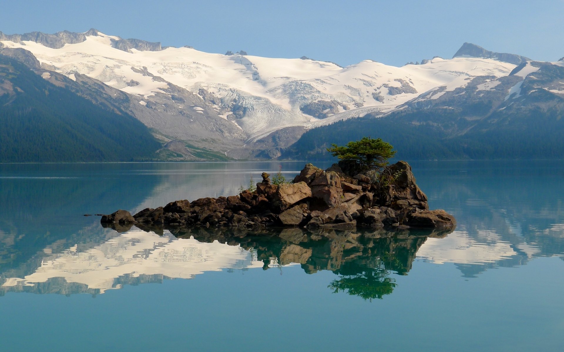 Nature HD PC desktop wallpaper background: Garibaldi Lake with a rocky islet and lone tree mirrored in glassy turquoise water, framed by snow-capped mountains and a clear blue sky.