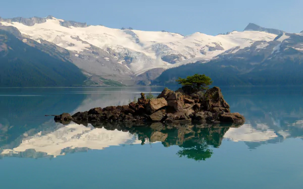 Nature HD PC desktop wallpaper background: Garibaldi Lake with a rocky islet and lone tree mirrored in glassy turquoise water, framed by snow-capped mountains and a clear blue sky.