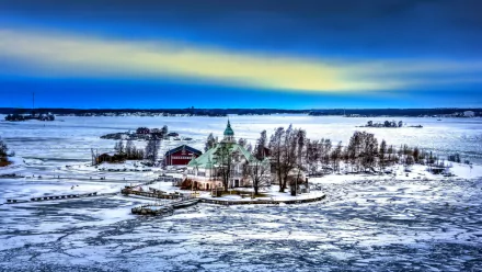 HD PC desktop wallpaper: a man-made villa on a tiny snowy island, surrounded by cracked sea ice beneath a dramatic blue and yellow dawn sky.