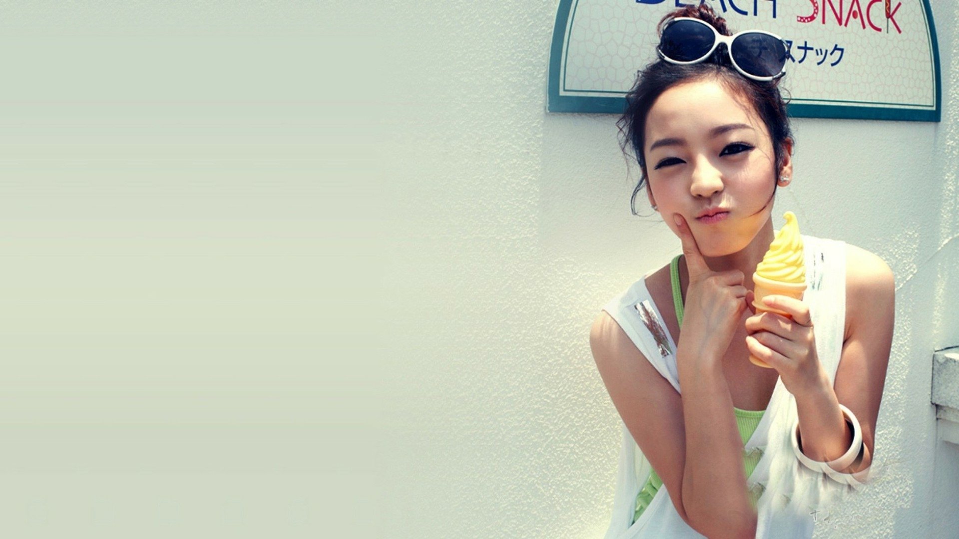 HD PC desktop wallpaper with Korean K-pop music vibe (tag: KARA) — young woman in sunglasses enjoying an ice cream cone against a pale wall.