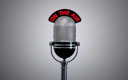 Vintage microphone with a red ON THE AIR sign, set against a subtle gray background, creating a retro music-themed HD desktop wallpaper.