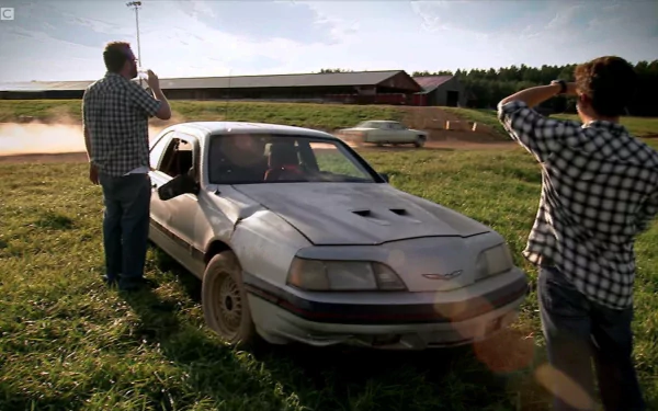 HD desktop wallpaper of a Top Gear scene with two people and a smoking car in a field.