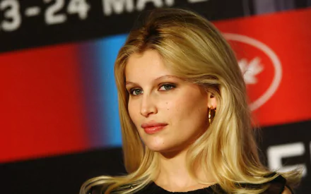 HD wallpaper featuring French model and celebrity Laetitia Casta with a confident expression against a vibrant backdrop.