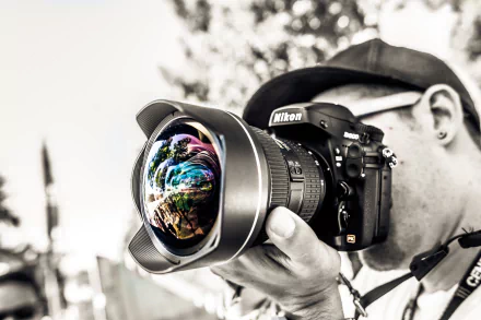 HD desktop wallpaper featuring a close-up of an individual using a Nikon D800 camera with a fisheye lens, capturing vivid reflections in an urban setting.