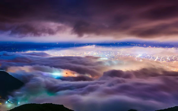 A fog-covered Taipei cityscape in Taiwan, China, with glowing lights piercing through the mist, showcased in a high-definition desktop wallpaper.