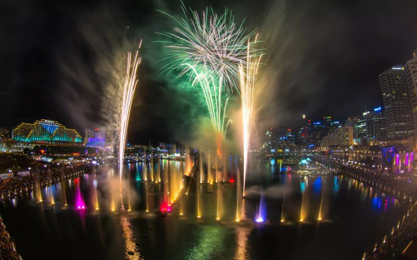 Vibrant fireworks light up the night sky over Darling Harbour, Sydney, Australia, with colorful water fountains enhancing this man-made HD desktop wallpaper scene.