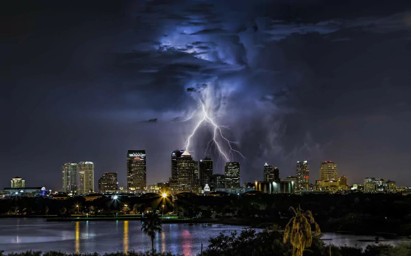 HD PC desktop wallpaper: Lightning over Tampa, Florida — dramatic storm above a man-made city skyline with reflections on water.
