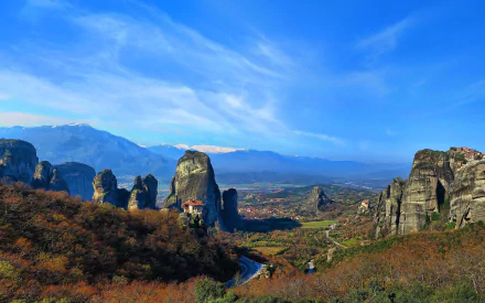 HD desktop wallpaper showcasing the stunning rocky landscape of Meteora with its iconic religious monasteries nestled atop towering cliffs under a vibrant blue sky.