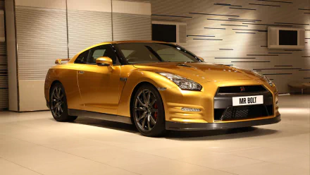 Gold Nissan GT‑R in a sleek showroom, presented as an HD PC desktop wallpaper background.