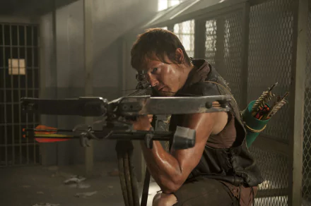 Norman Reedus as Daryl Dixon, aiming a crossbow in a prison setting from the TV show The Walking Dead. HD desktop wallpaper and background image.