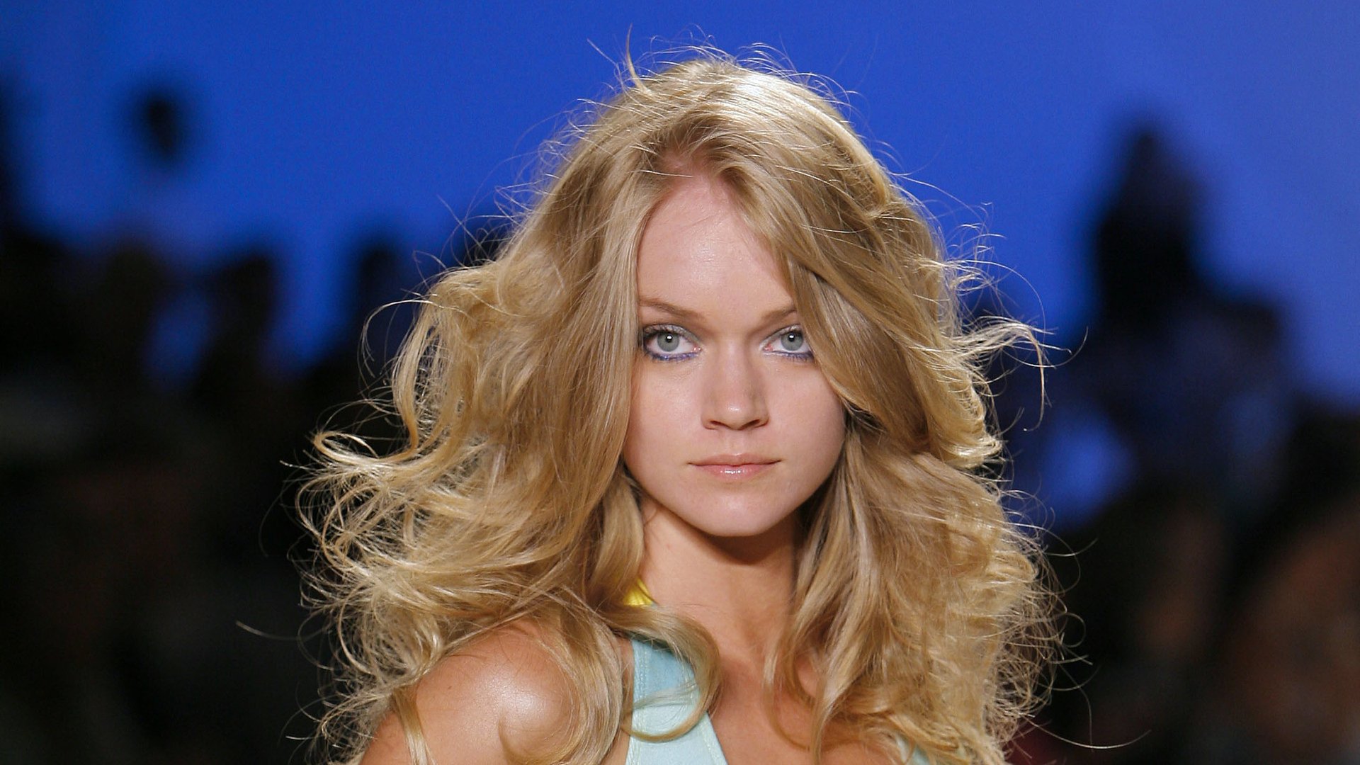 HD desktop wallpaper featuring American model Lindsay Ellingson with flowing blonde hair against a blurred blue background.
