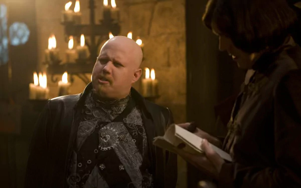 Kröd Mändoon and the Flaming Sword of Fire TV show HD desktop wallpaper: bald man in ornate dark robes in a candlelit medieval chamber speaking to a robed scribe.