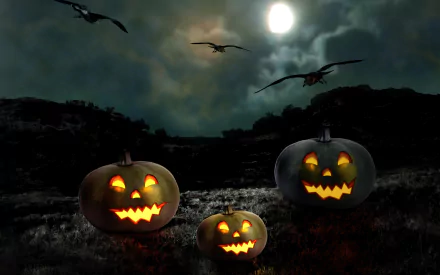 A dark Halloween-themed desktop wallpaper featuring three carved pumpkins with glowing faces, set against a moody night sky and flying bats.