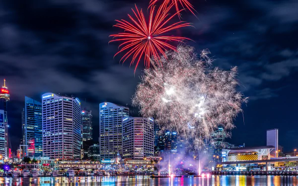 Nighttime fireworks illuminate Sydney's Darling Harbour skyline in this vibrant 4K Ultra HD desktop wallpaper, showcasing the city's dynamic architecture and festive atmosphere.