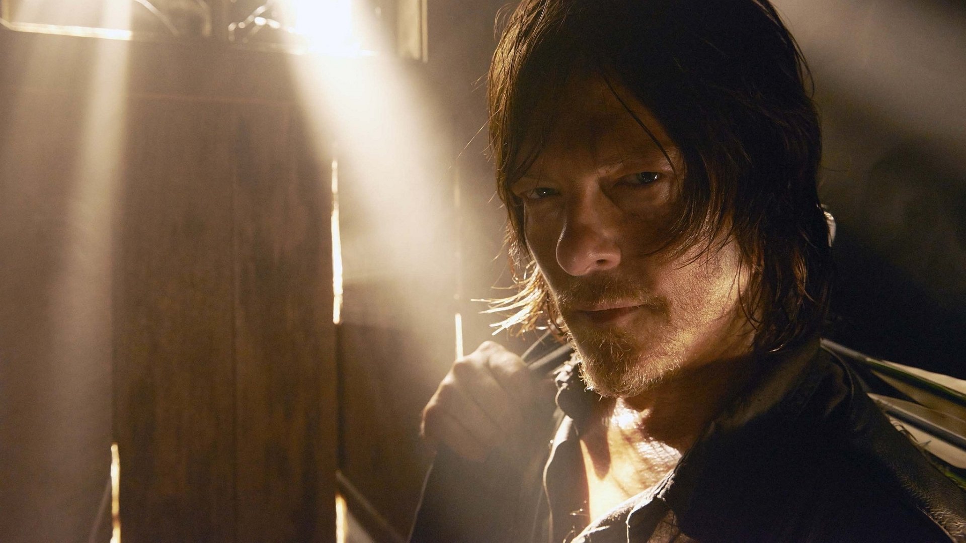 A moody HD wallpaper featuring a character from the TV show The Walking Dead, bathed in light, conveying a tense atmosphere.