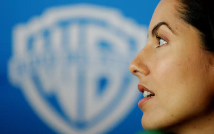Close-up profile of Mexican actress Barbara Mori, featuring her expressive features against a blurred Warner Bros. backdrop, creating a striking HD desktop wallpaper.