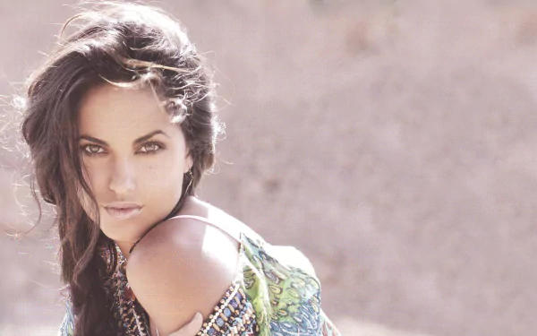 A striking HD desktop wallpaper featuring Mexican actress Barbara Mori, showcasing her captivating gaze and stylish outfit against a soft, blurred background.