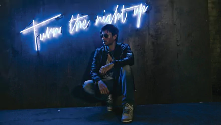 A striking HD desktop wallpaper featuring Enrique Iglesias, posed against a dark wall illuminated by neon text that reads Turn the night up.