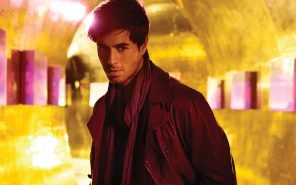 HD desktop wallpaper featuring Enrique Iglesias, captured in a striking pose with a golden backdrop, blending music and artistry in a captivating visual experience.