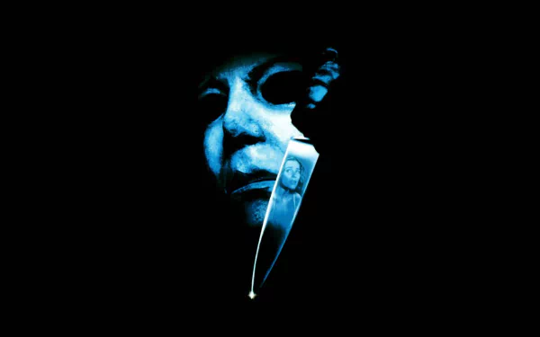 HD PC desktop wallpaper from the movie Halloween: The Curse of Michael Myers, featuring a dark, eerie close-up of Michael Myers' mask and a reflective knife blade.