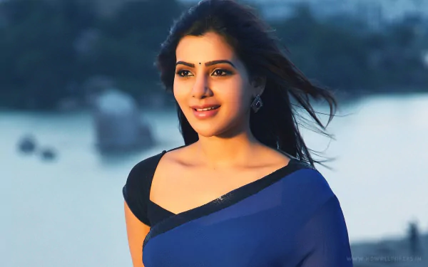 HD desktop wallpaper featuring Bollywood celebrity Samantha Akkineni smiling and wearing a blue outfit, set against a serene background.