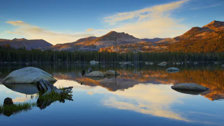 A serene nature scene with mountains and trees reflected in calm water, captured in stunning 4K Ultra HD for a vivid PC desktop wallpaper.