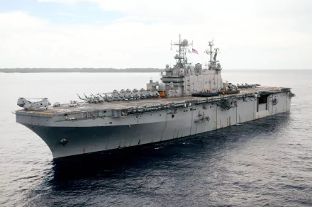 An HD image of the USS Peleliu (LHA-5), an amphibious assault ship from World War II, showcasing its helicopter deck and military design against a tranquil sea backdrop.