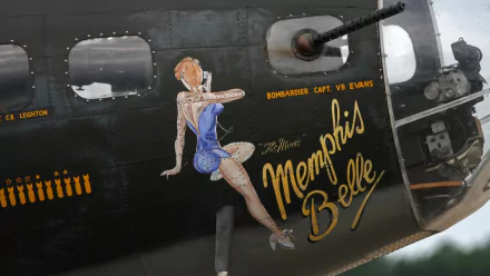 HD PC desktop wallpaper and background showing military aircraft nose art: Memphis Belle pinup painted on a bomber fuselage beside a gun turret.