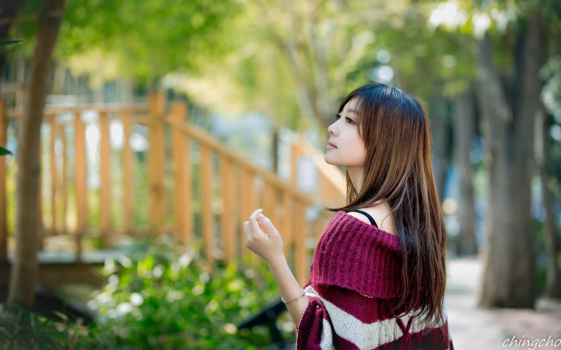 HD wallpaper featuring a Taiwanese woman named Patty Yong, standing outdoors with lush green trees and a wooden fence in the background.