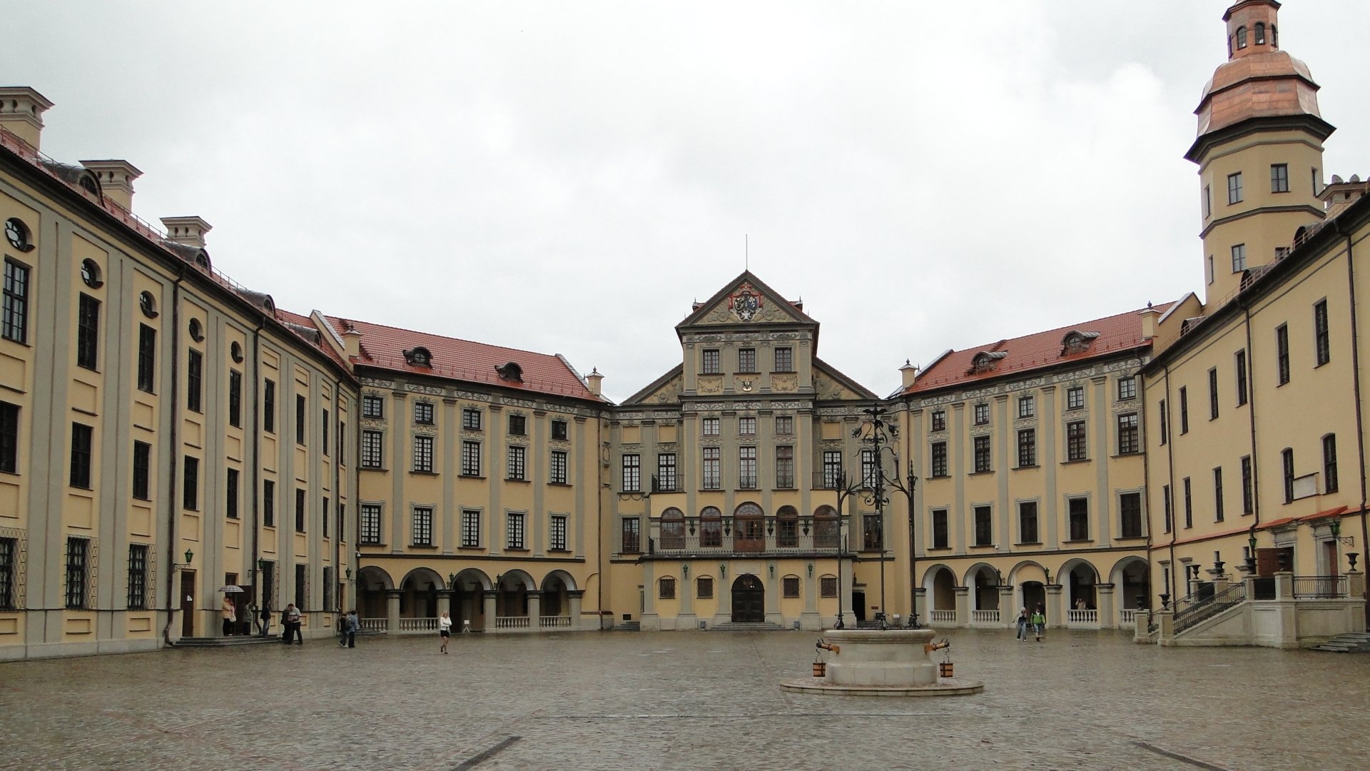 Man-made Nesvizh Castle courtyard under an overcast sky with symmetrical baroque facades — HD PC desktop wallpaper and background.