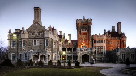 HD PC desktop wallpaper of Casa Loma: a man-made Gothic Revival castle at dusk, stone façades, towers and warm lights against a twilight sky.